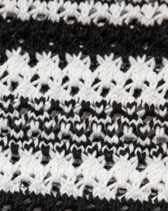 Close-up of the LSPACE Caicos Skirt in caicos stripe, showing the crochet fabric texture in alternating black and cream horizontal stripe patterns.
