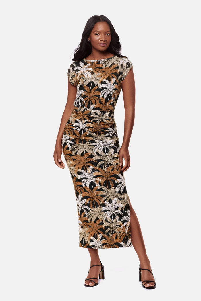 Woman wearing a short sleeve full length dress with a multicolored palm tree print