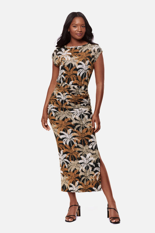 Woman wearing a short sleeve full length dress with a multicolored palm tree print
