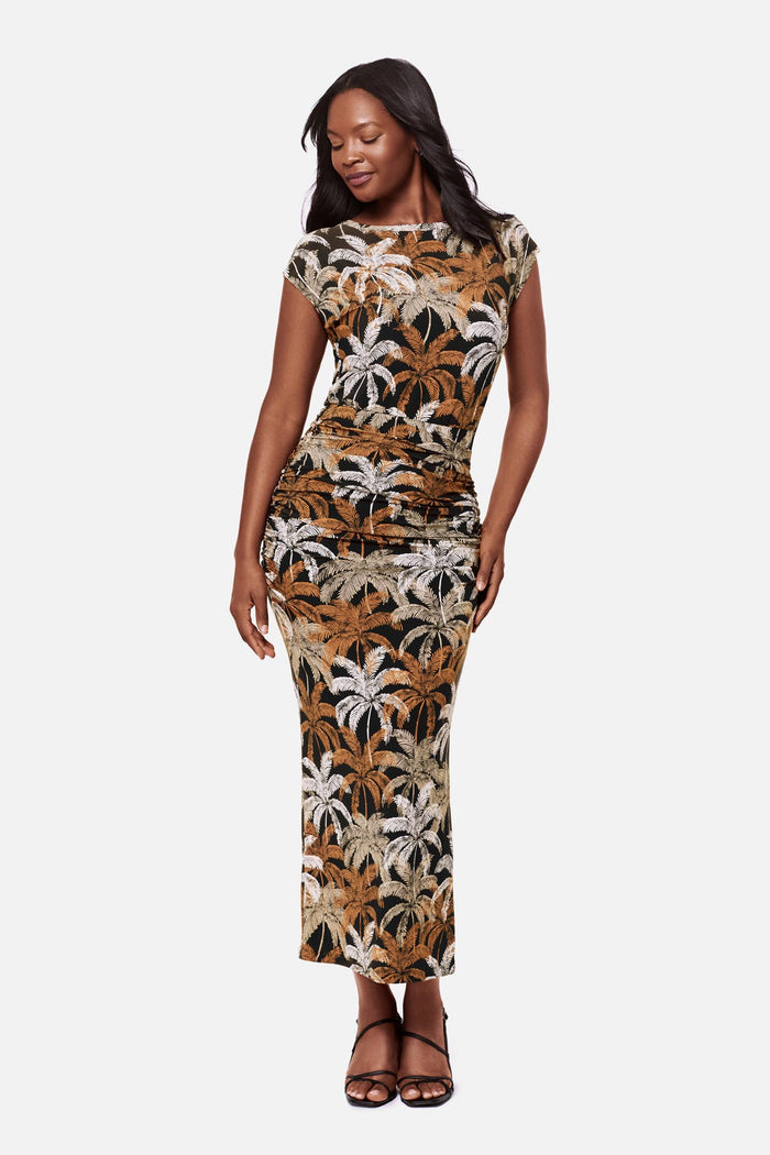 Woman wearing a short sleeve full length dress with a multicolored palm tree print