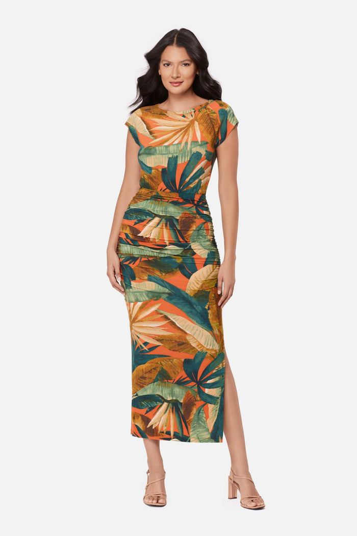 Woman wearing a short sleeve full-length dress with a multicolored tropical print