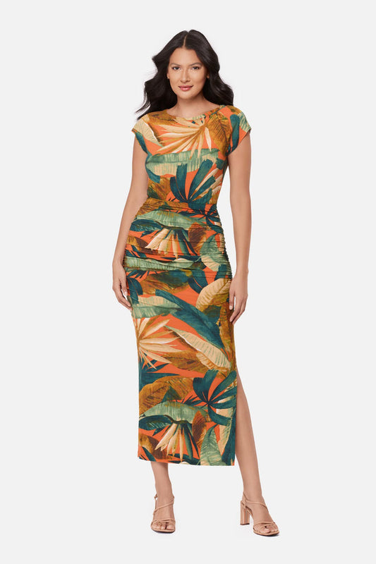 Woman wearing a short sleeve full-length dress with a multicolored tropical print