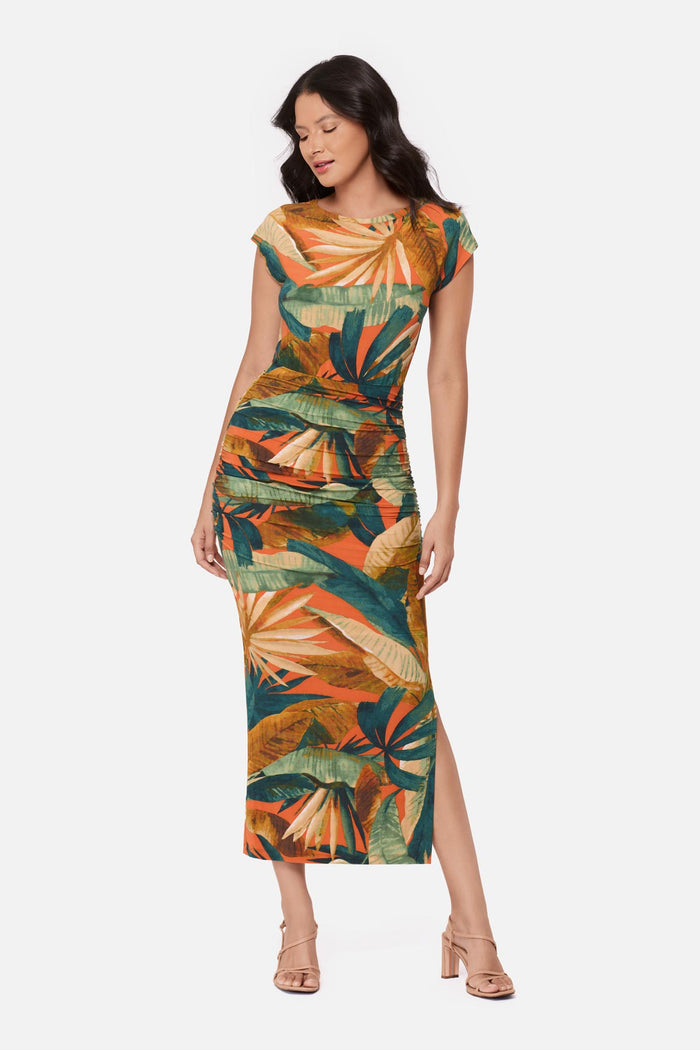 Woman wearing a short sleeve full-length dress with a multicolored tropical print