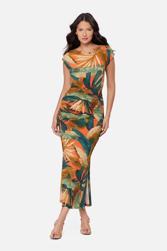 Woman wearing a short sleeve full-length dress with a multicolored tropical print