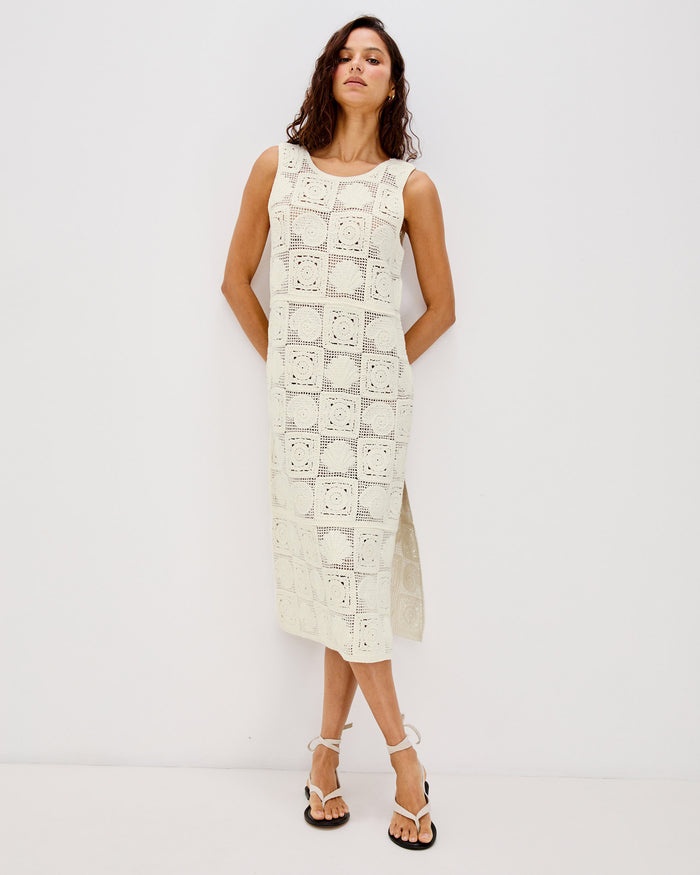 Front view of a model wearing the LSPACE Calla Dress in cream, displaying the full-length crochet silhouette with a side slit at the hem.