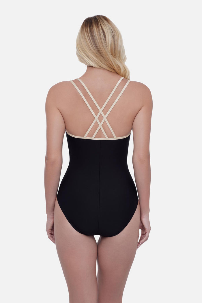 Woman turned away wearing a black one-piece swimsuit with white double straps