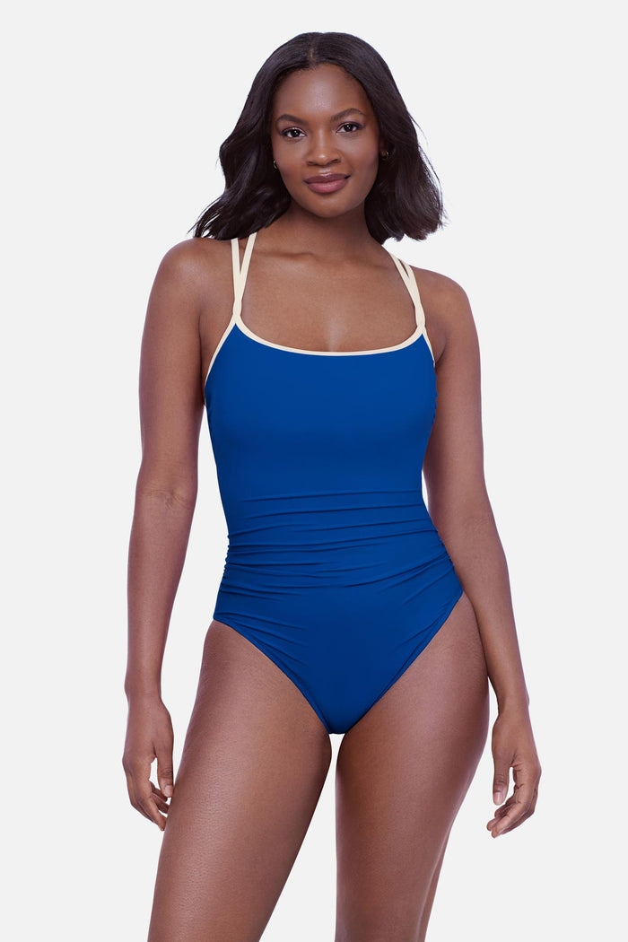 Woman wearing a blue one-piece swimsuit with white double straps