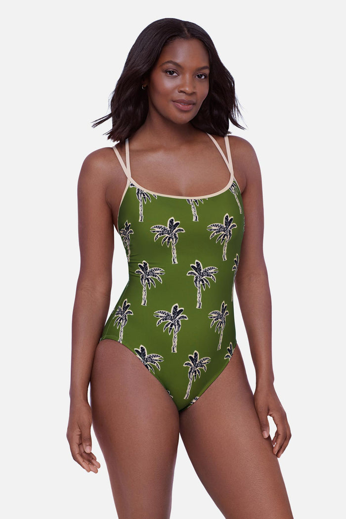 Woman wearing a green palm tree printed one-piece swimsuit