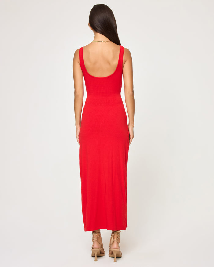 Back view of a model wearing the LSPACE Camille Dress in flame, showing the open-back scoop neckline and the ribbed midi-length skirt.