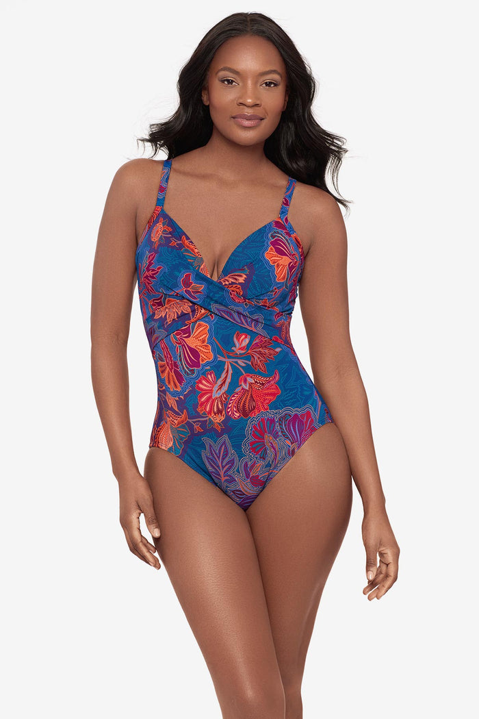 Woman wearing a one-piece swimsuit with a red and orange flower print