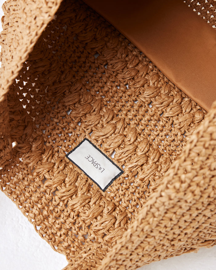 Close-up interior view of the Changing Tides Bag in natural showing the LSPACE branding label.