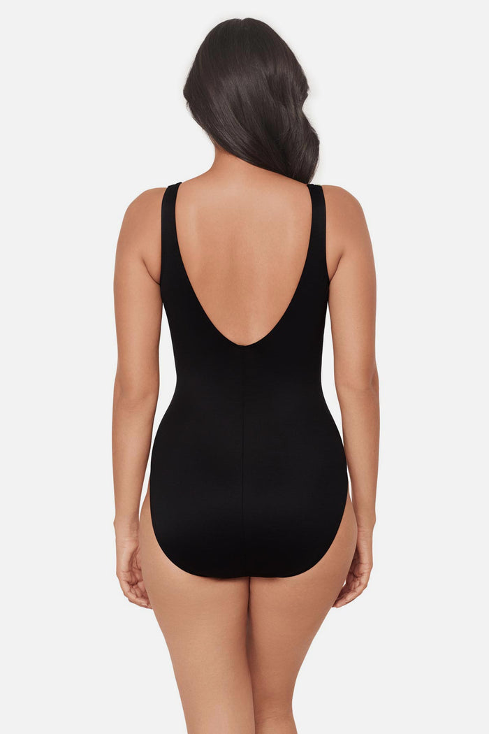 Woman turned away wearing a multicolored geometric printed V neck one-piece swimsuit