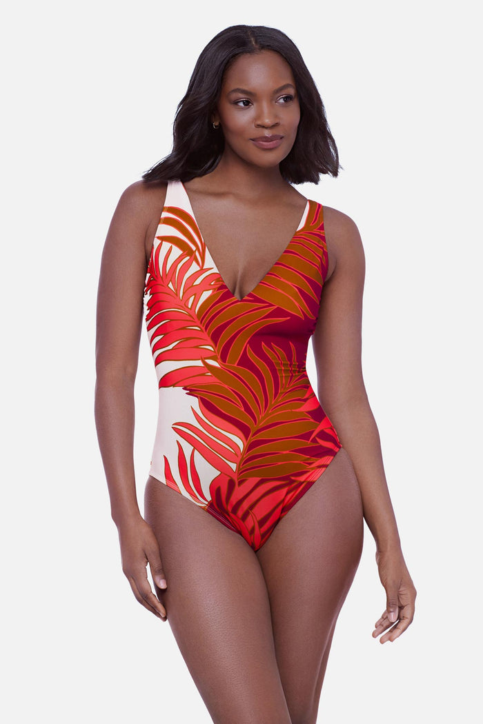 Woman wearing an orange and white palm leaf printed one-piece swimsuit