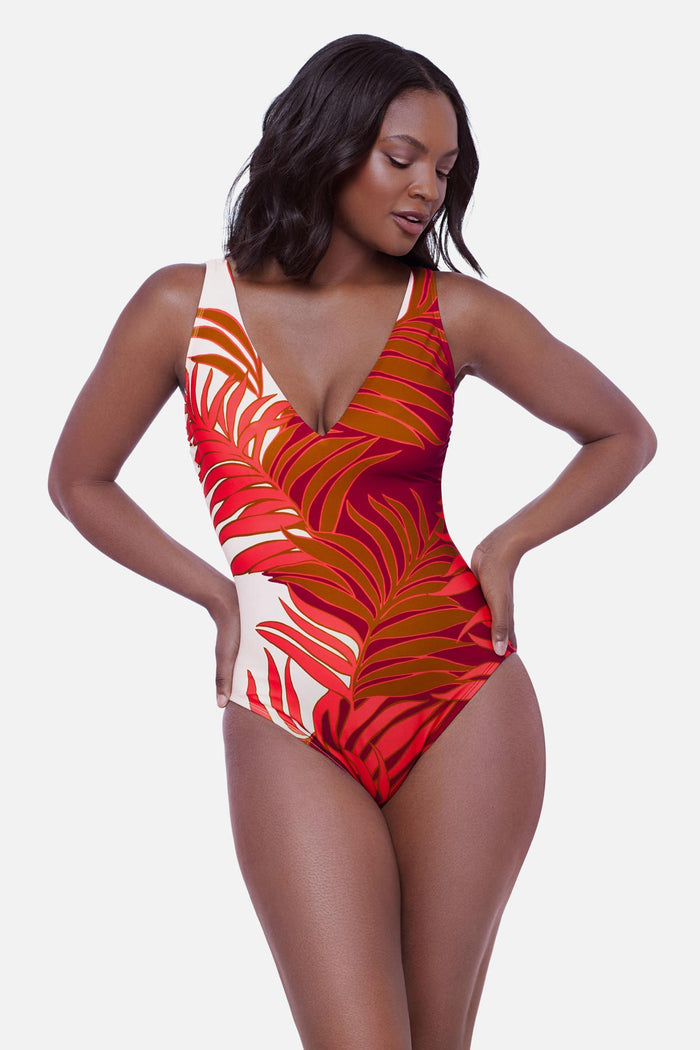 Woman wearing an orange and white palm leaf printed one-piece swimsuit