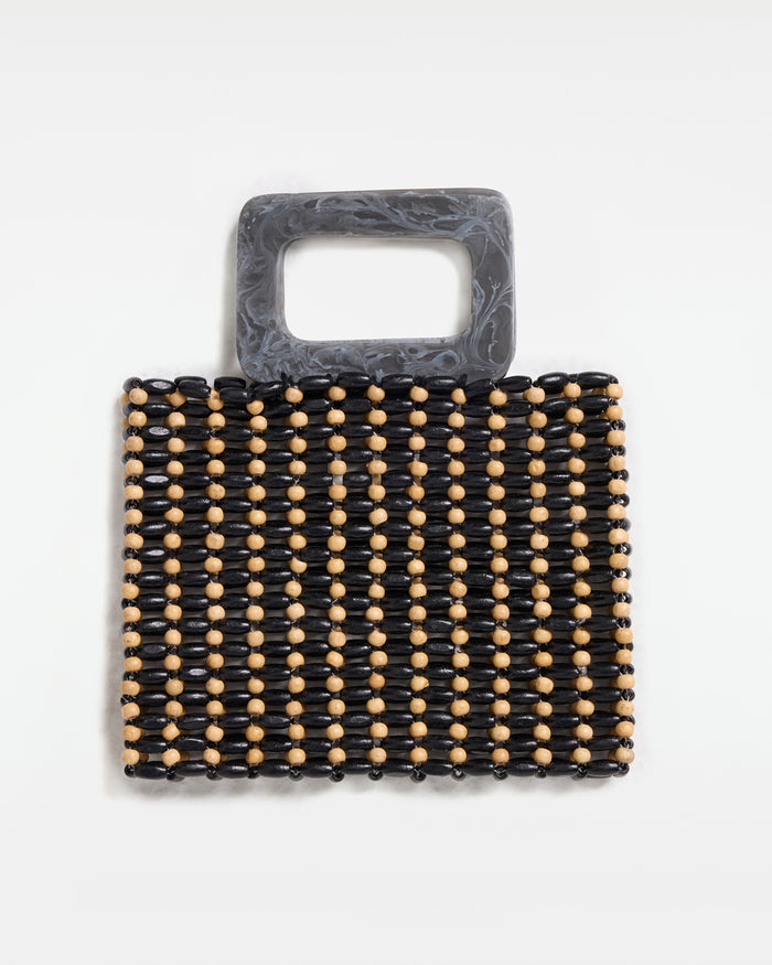 Off-model front view of the Chiado Bag in natural-black, a structured beaded tote bag with alternating black and natural wood beads and a grey marbled acrylic top handle, on a white background.