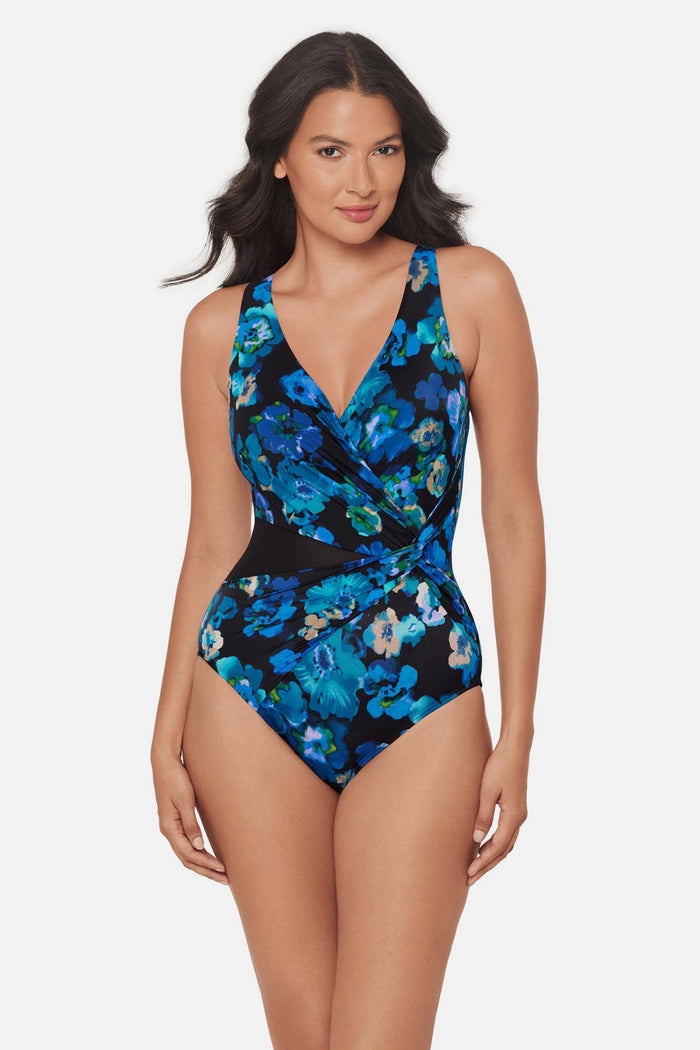 Woman wearing a black and blue floral printed one-piece swimsuit