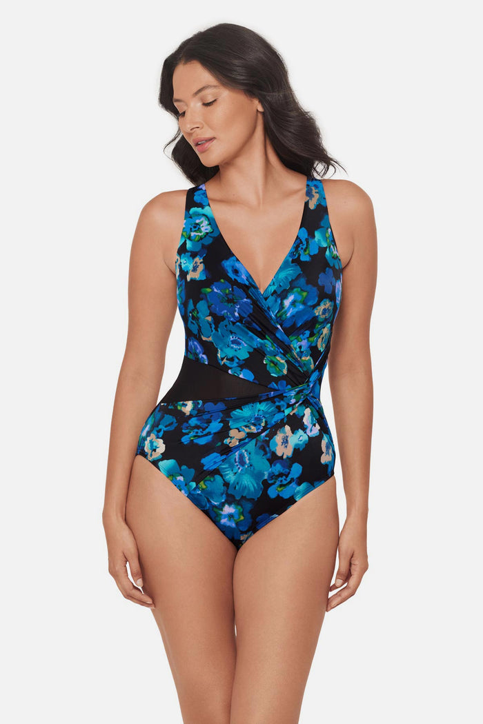 Woman wearing a black and blue floral printed one-piece swimsuit