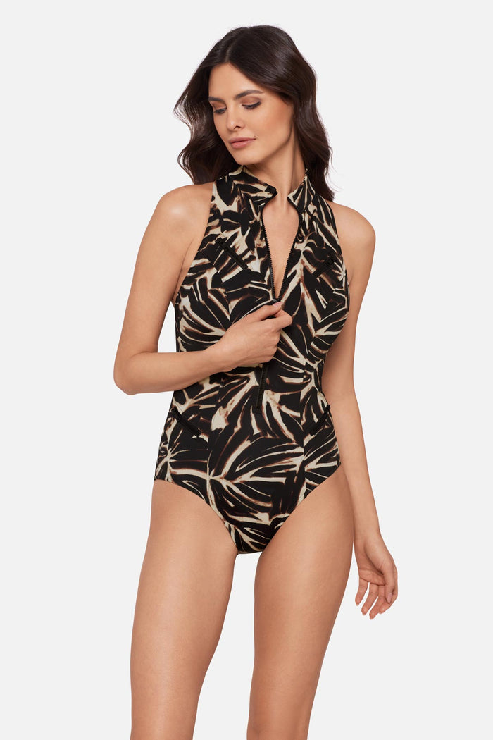 Woman wearing an abstract printed one-piece swimsuit with a zipper detail down the front