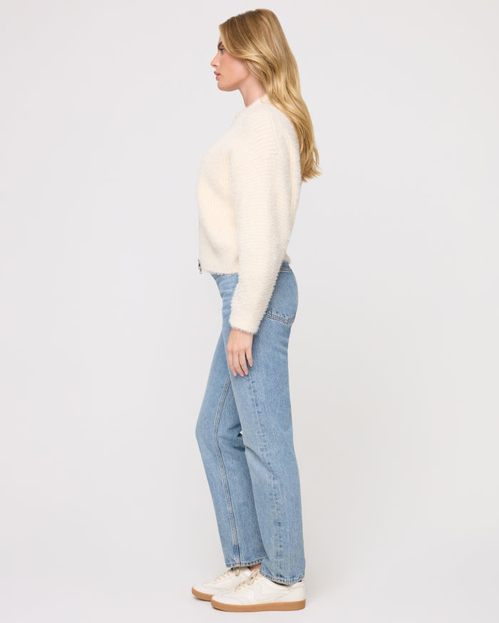 Side view of a model wearing the LSPACE Cosmos Sweater in tapioca, showing the cropped length and fuzzy texture of the open-front sweater.