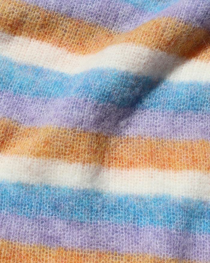 Close-up of the LSPACE Cozy Clouds Sweater in beautiful skies stripe, showing the soft fuzzy knit fabric texture with horizontal stripes in blue, lavender, tan, and white.