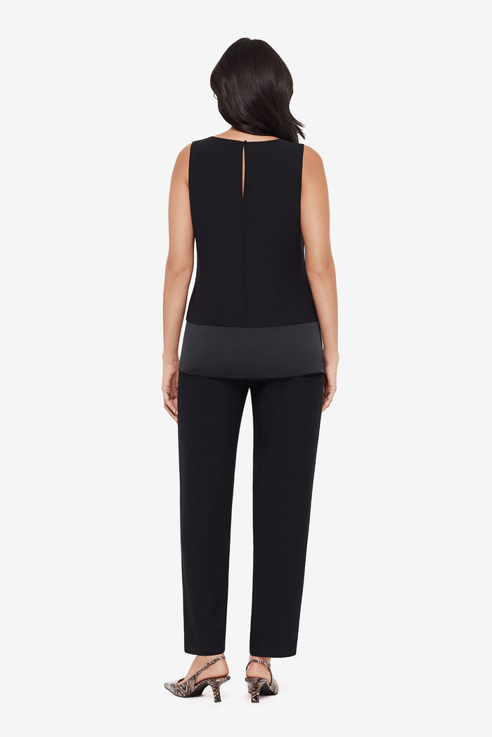 Woman turned away wearing a black layered tunic top with matching jogger pants