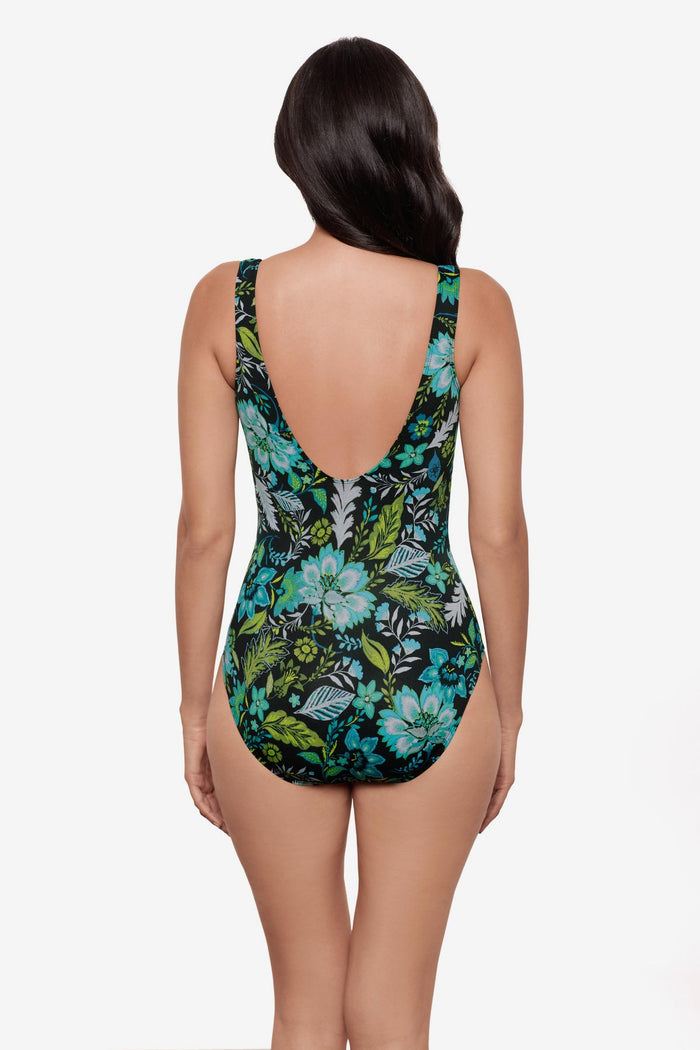Woman faced away wearing a multicolored floral printed one-piece swimsuit