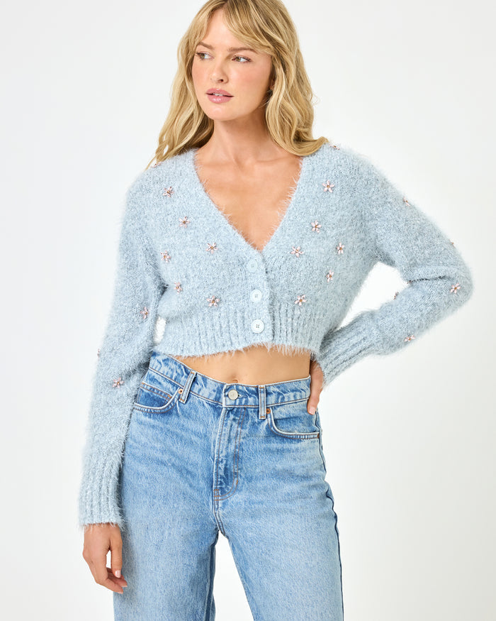Close-up front view of a model wearing the LSPACE Crystal Cardigan in dove, showcasing the fluffy knit fabric, crystal floral embellishments, and button-front detail of the cropped cardigan.