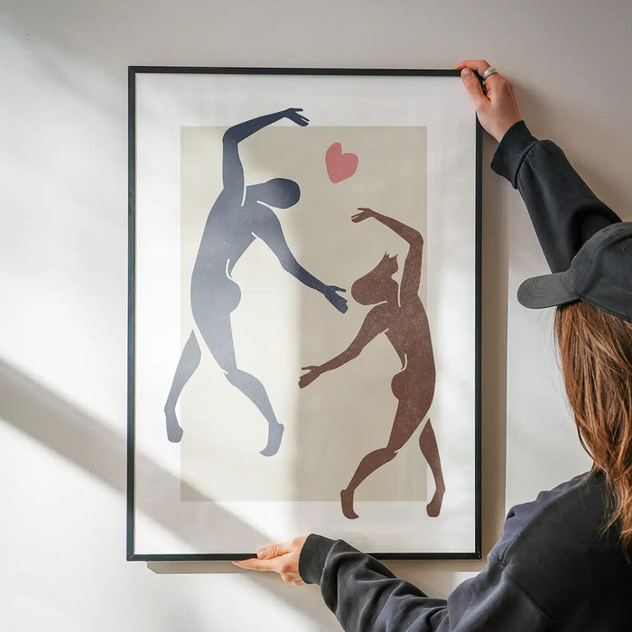 Dancers Watercolour Style Print being hung on a wall in a black frame