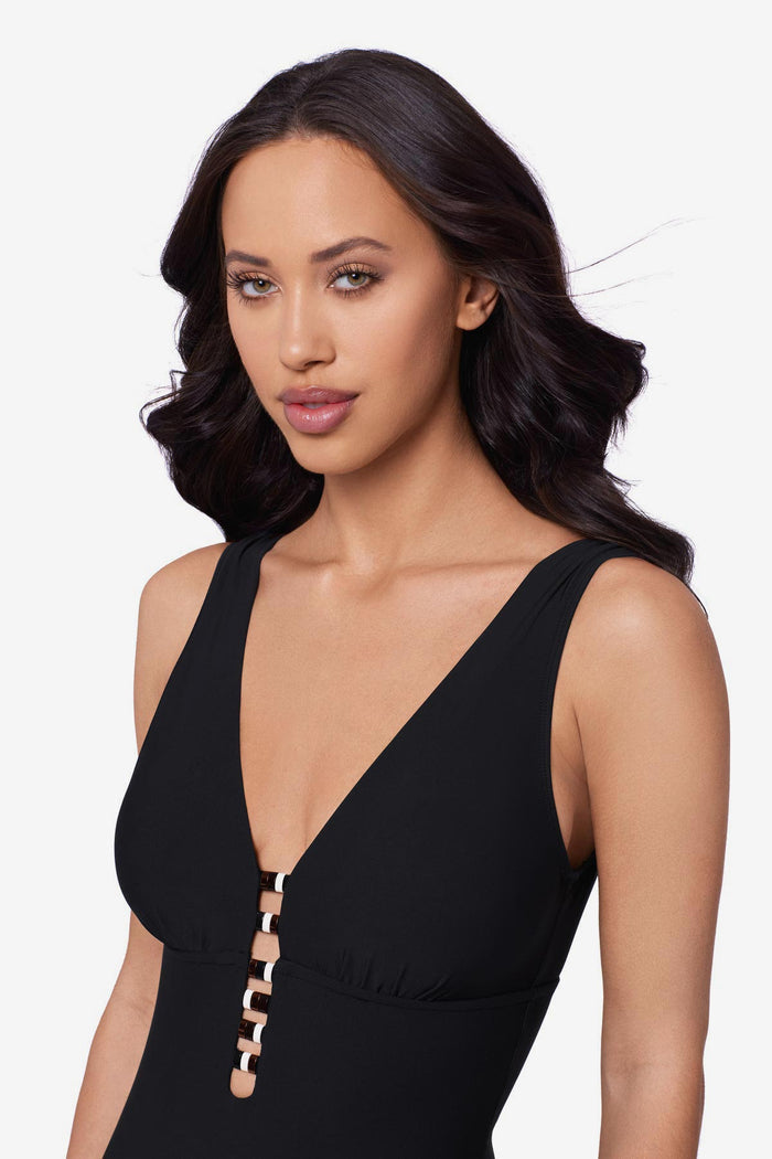 Close up of woman wearing a black one-piece swimsuit with beading down the front