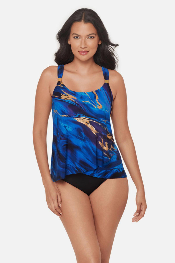 Woman wearing a blue and gold oil slick-esque printed tankini top