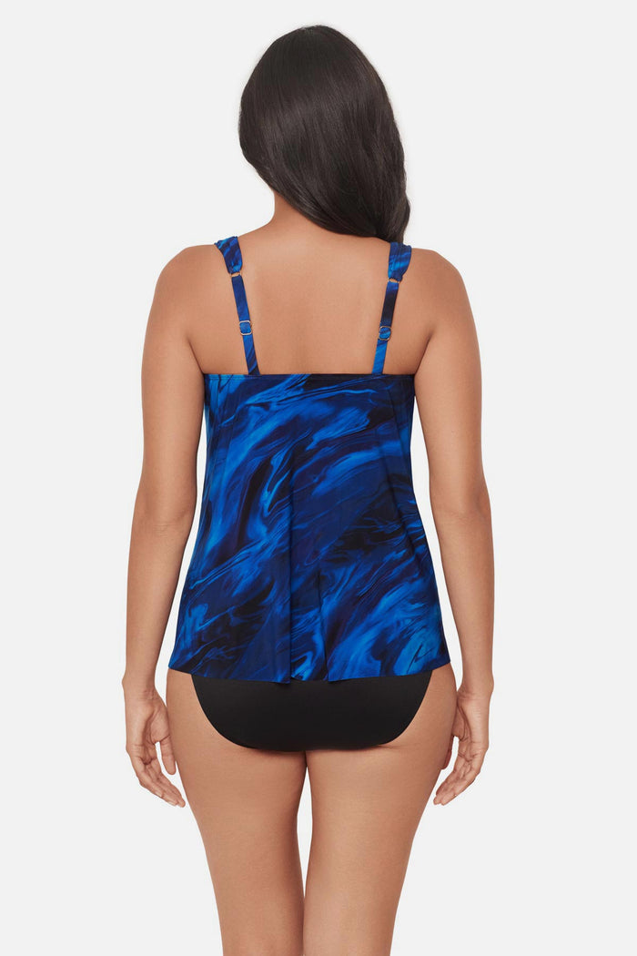 Woman turned away wearing a blue and gold oil slick-esque printed tankini top