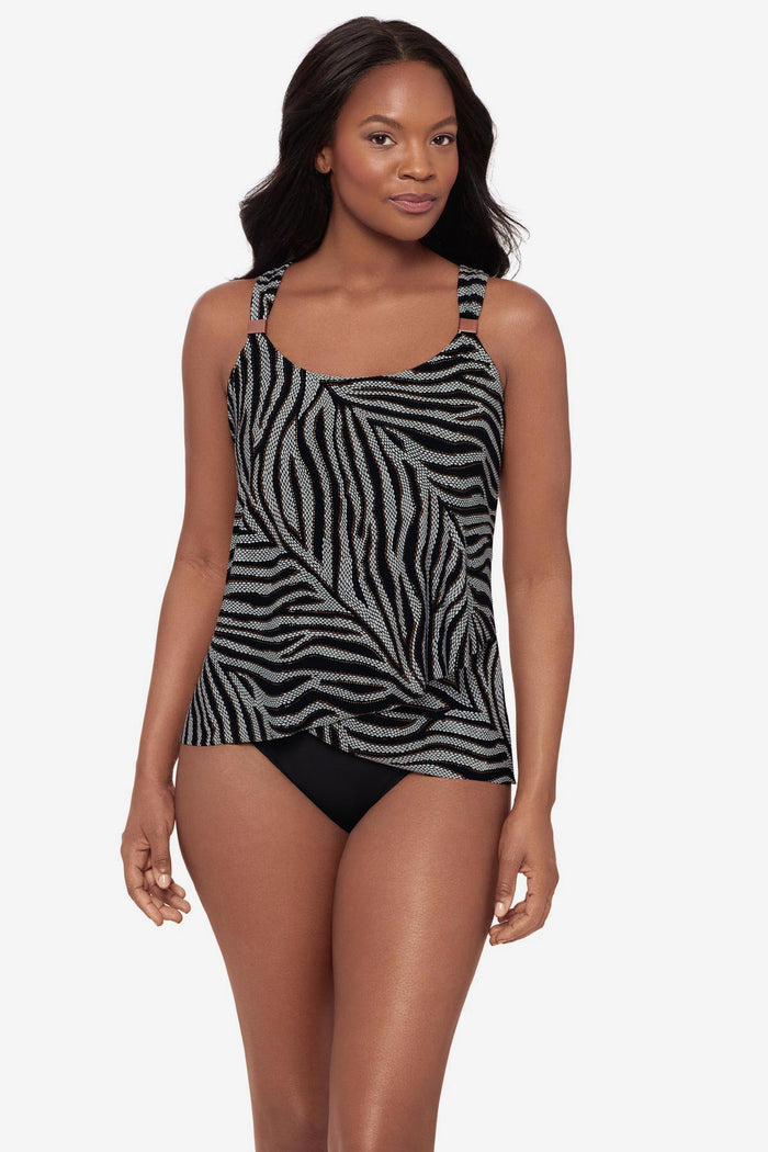 Woman wearing an animal print-esque tankini top with embellishments on the straps