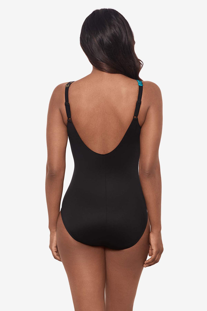 Woman facing away wearing a  multicolor one-piece swimsuit