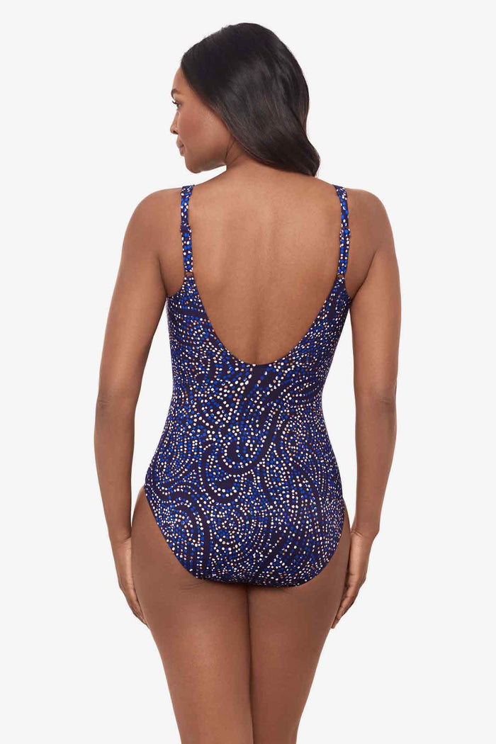 Woman facing away wearing a one-piece multicolor swimsuit