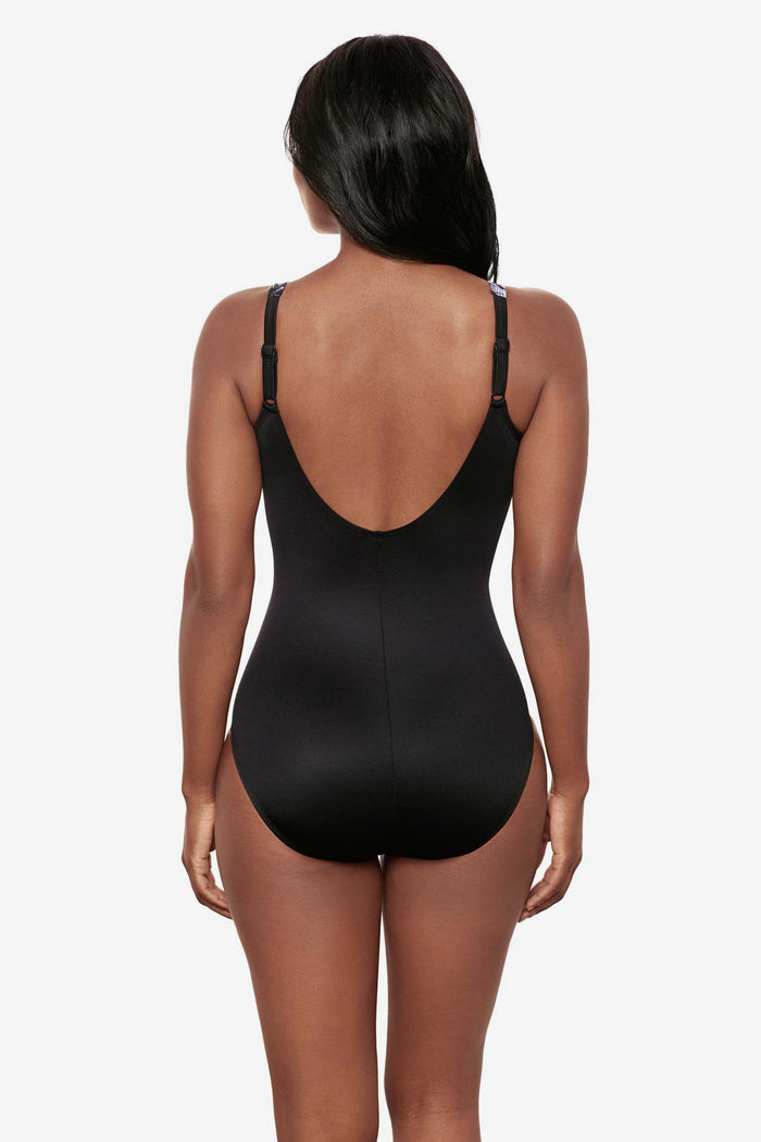 Woman turned away wearing a white floral print one-piece swimsuit