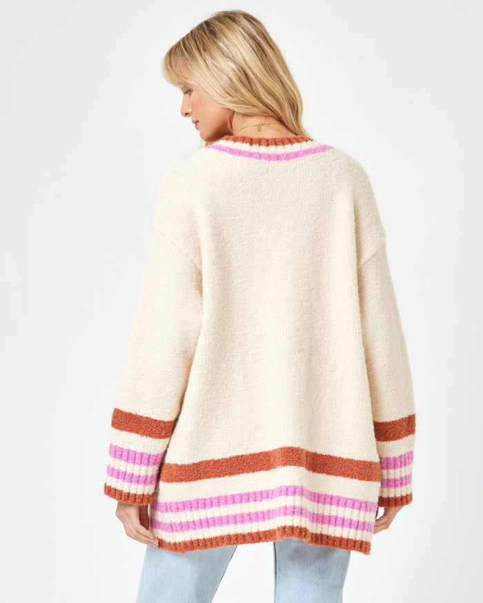 Back view of a model wearing the LSPACE Delta Blooms Sweater in delta blooms jacquard, showing the floral jacquard knit pattern across the back of the pullover sweater.