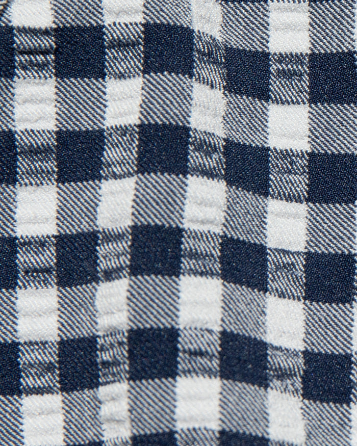 Close-up detail of the atta girl gingham fabric of the LSPACE Dolce Bikini Bottom, showing a navy and white woven gingham check pattern.