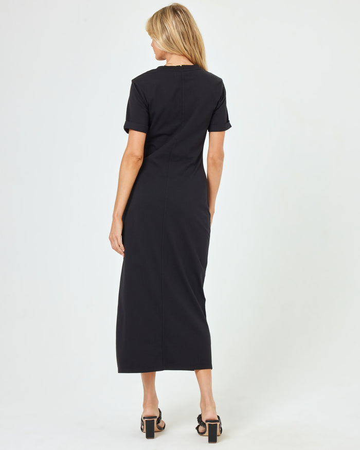 Back view of a model wearing the LSPACE Drew Dress in black, a short-sleeve jersey midi dress.