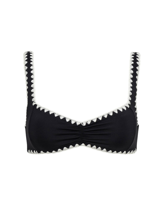 Off-model flat lay view of the LSPACE Effie Bikini Top in Black-Cream on a white background, a black bralette-style bikini top with cream zig-zag trim along the neckline, shoulder straps, and edges, featuring a center ruched detail.