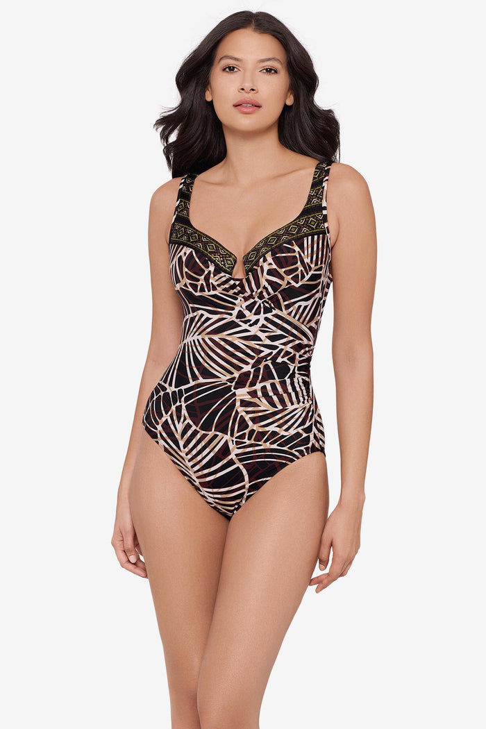 Woman wearing a brown abstract printed one-piece swimsuit with a detailed print on the sweetheart neckline