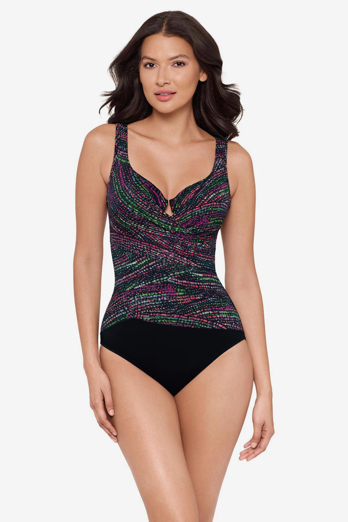 Woman wearing a multicolor one-piece swimsuit with a black panel at the bottom
