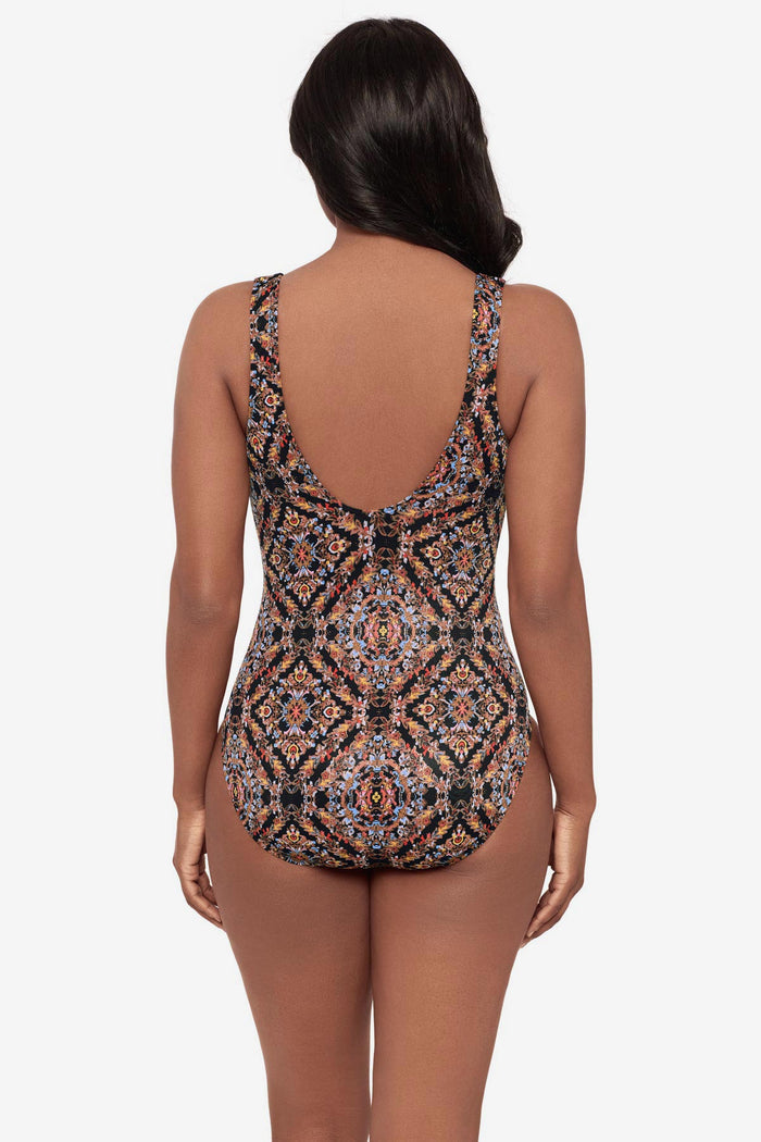 Woman turned away wearing a multicolor abstract one-piece swimsuit