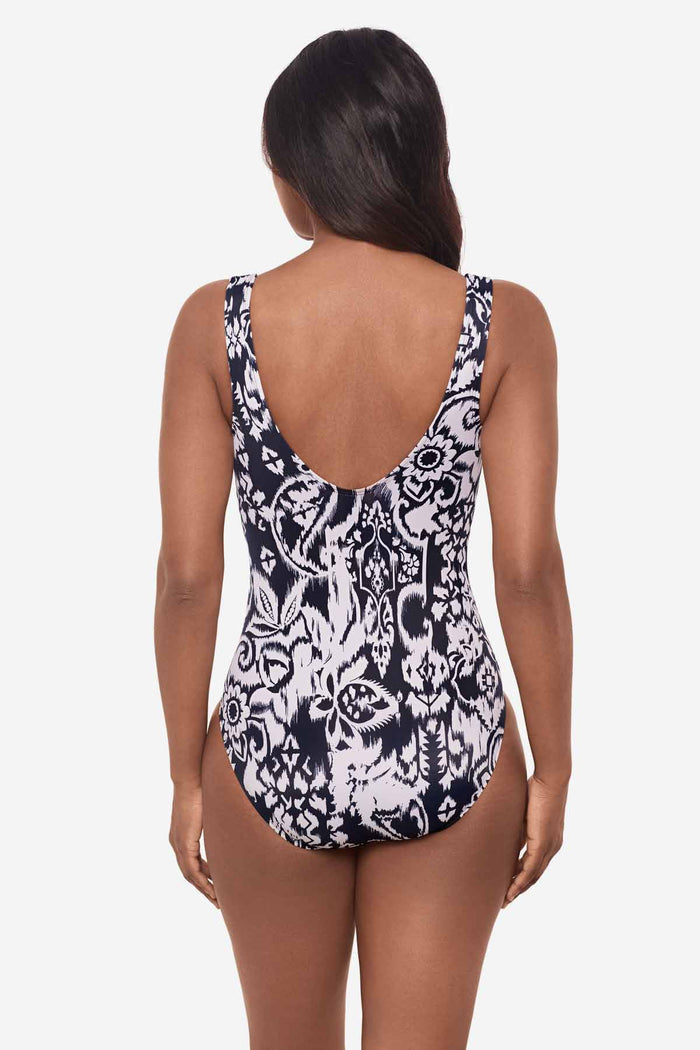 Woman facing away wearing a blue and white one-piece swimsuit