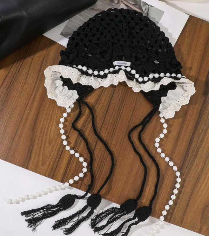 Black crochet head bonnet with ruffled white lace, pearl strings, and tassels