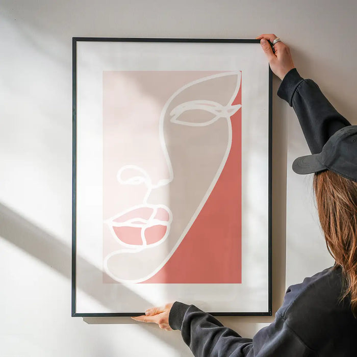 Face Study Block Colours Print being hung on a wall in a black frame
