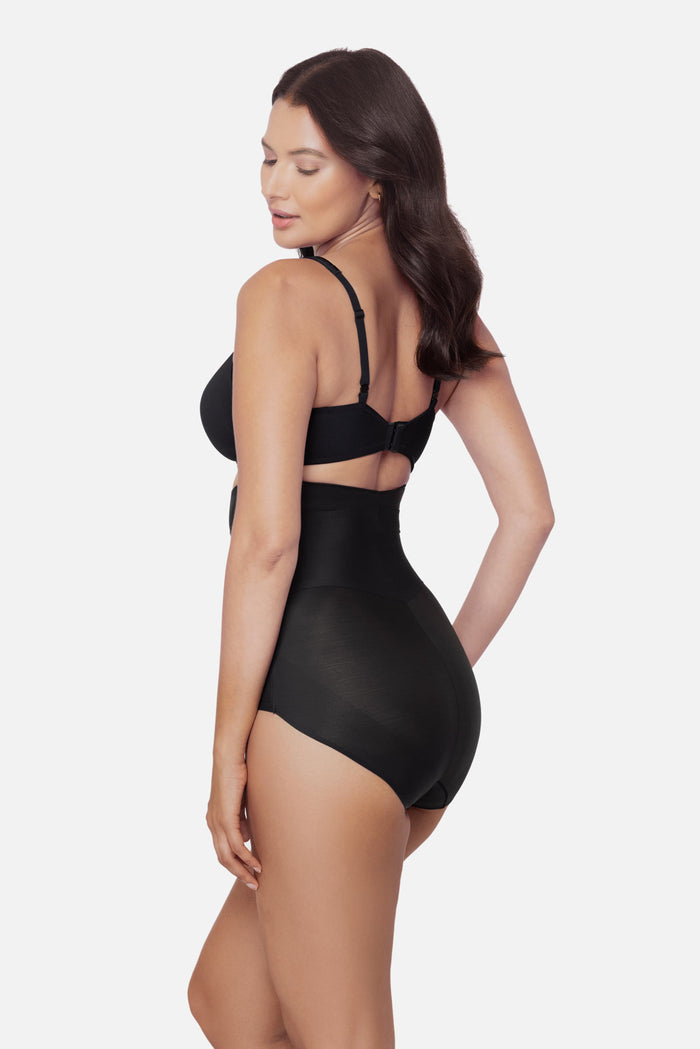 Woman turned left wearing a black high waisted brief shapewear