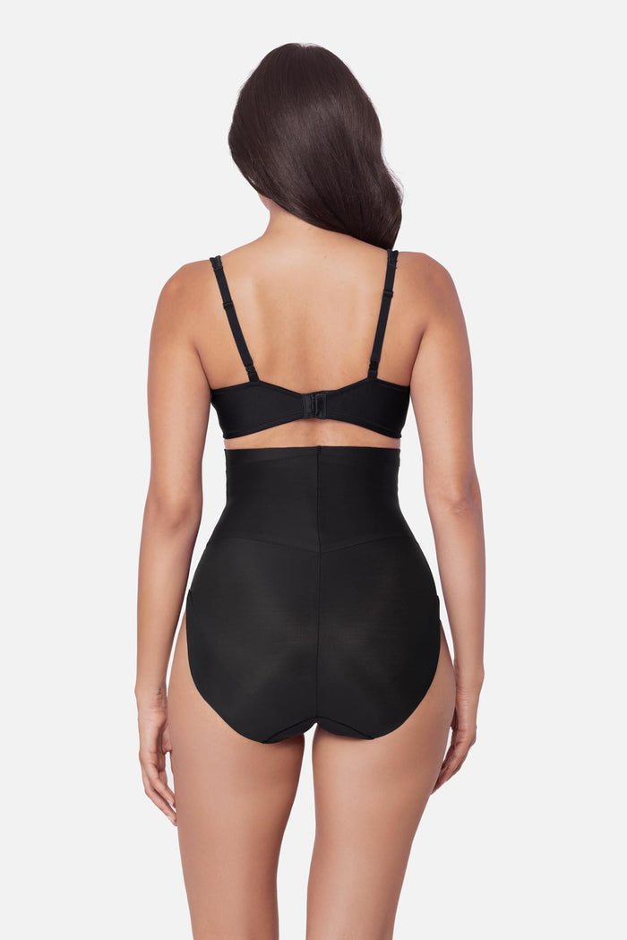 Woman faced away wearing a black high waisted brief shapewear