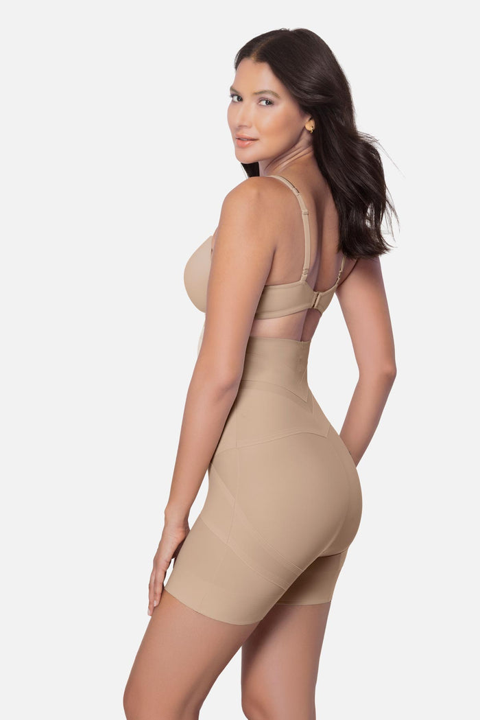 Woman turned left wearing a beige high waisted mid-thigh shapewear pant