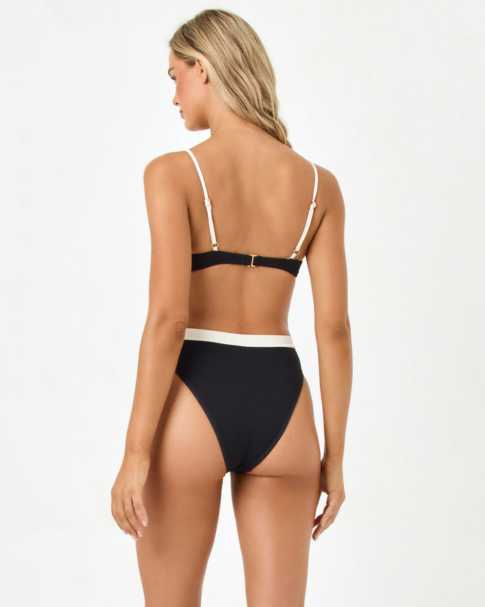 Back view of a model wearing the LSPACE Black-Cream Sunrise Shell Bikini Top and Frenchi Bikini Bottom.