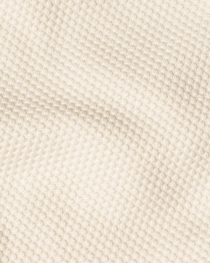 Close-up detail of the cream fabric texture used in the LSPACE Frenchi Bikini Bottom, showing a pique bubble weave pattern.